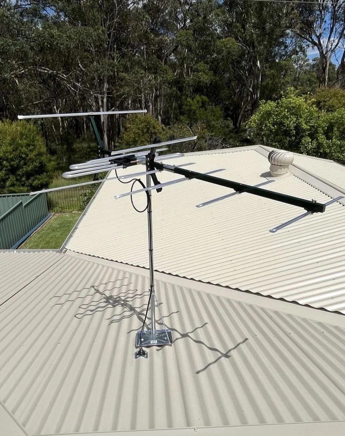 A television antenna installed on a metal roof by C3 Industries