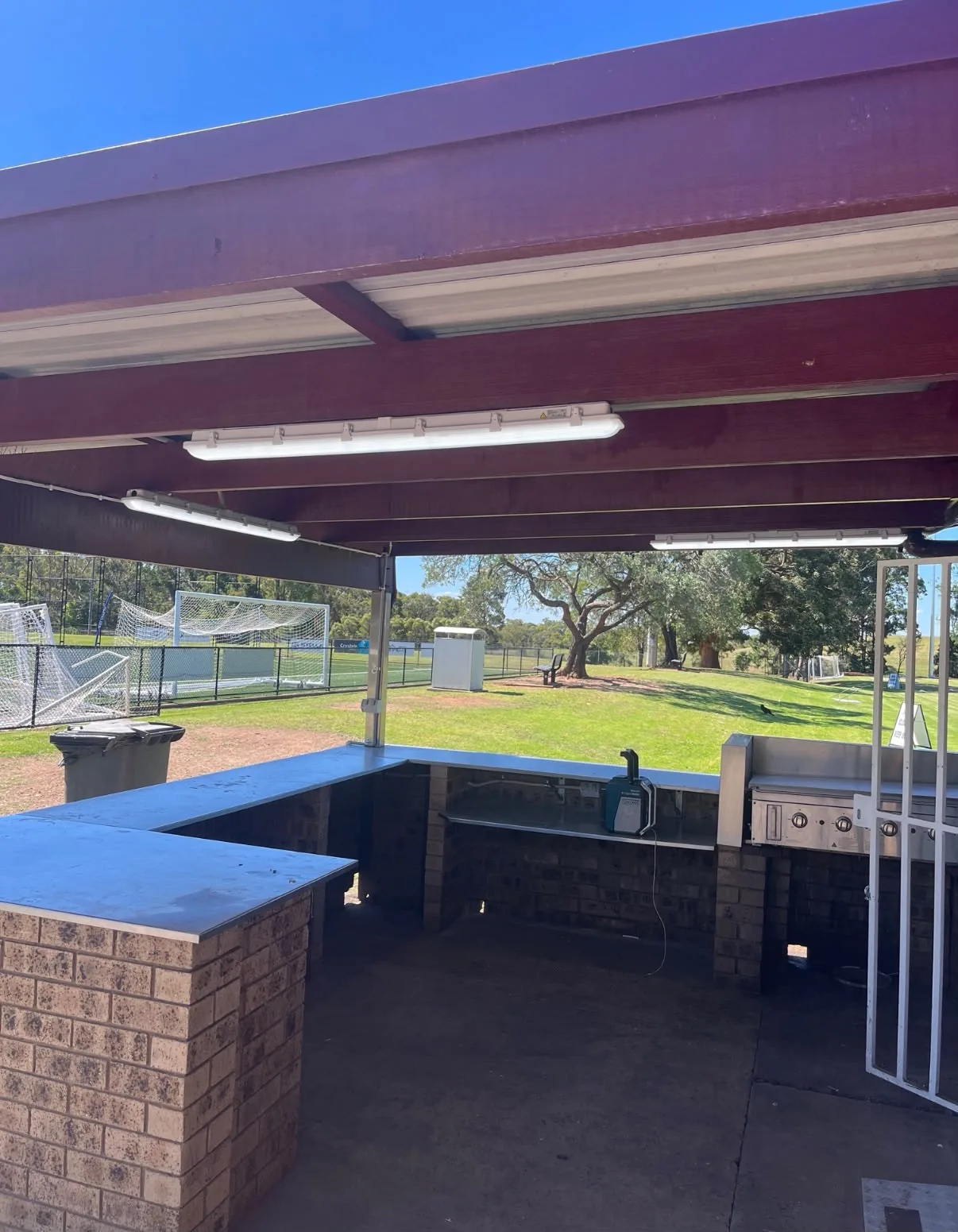 Weatherproof batten lighting installed above a sports club canteen and barbecue area