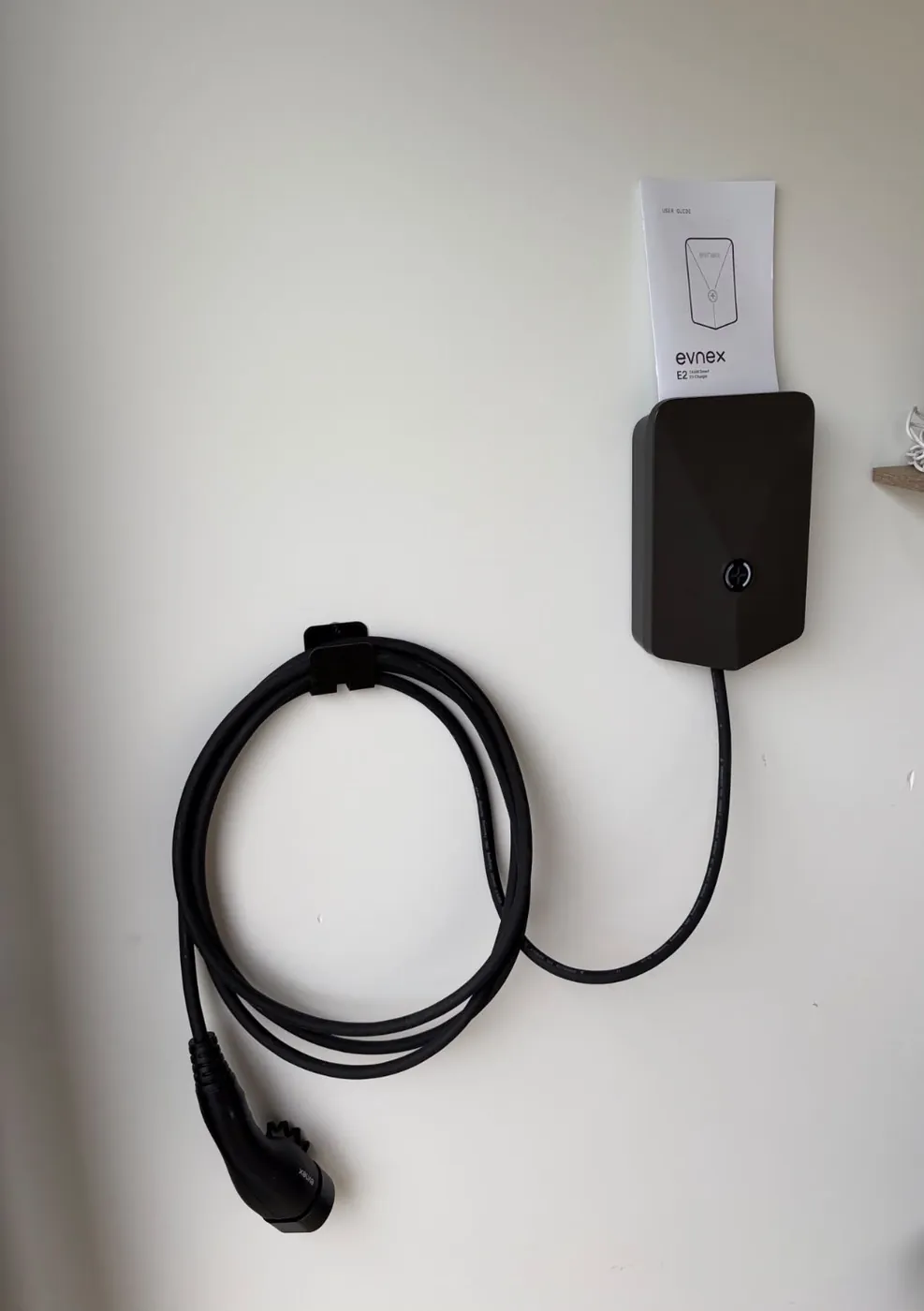 A wall-mounted EV charger installed by C3 Industries with the lead coiled beside it
