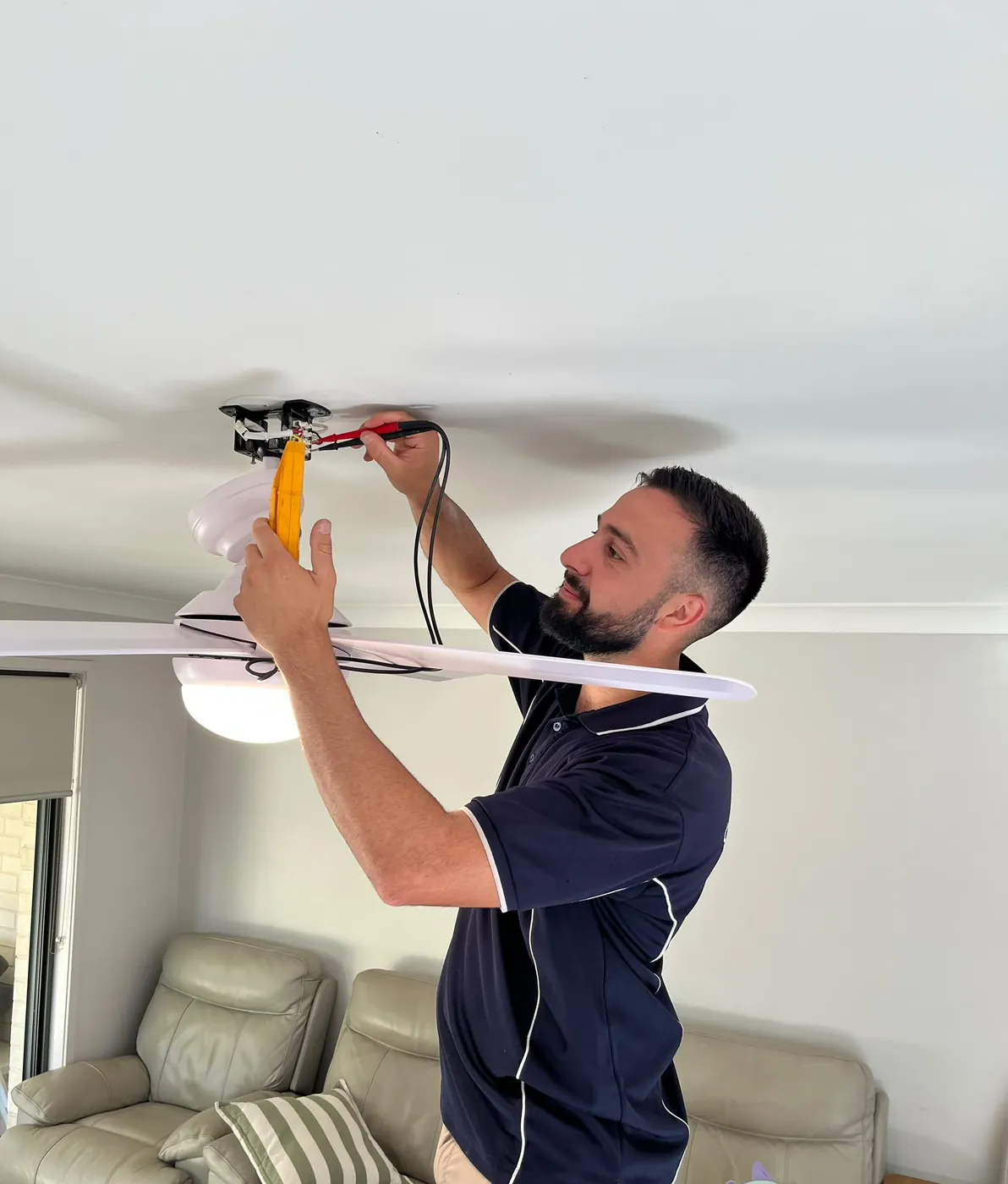 Kalin of C3 Industries wiring a ceiling fan into the ceiling rose