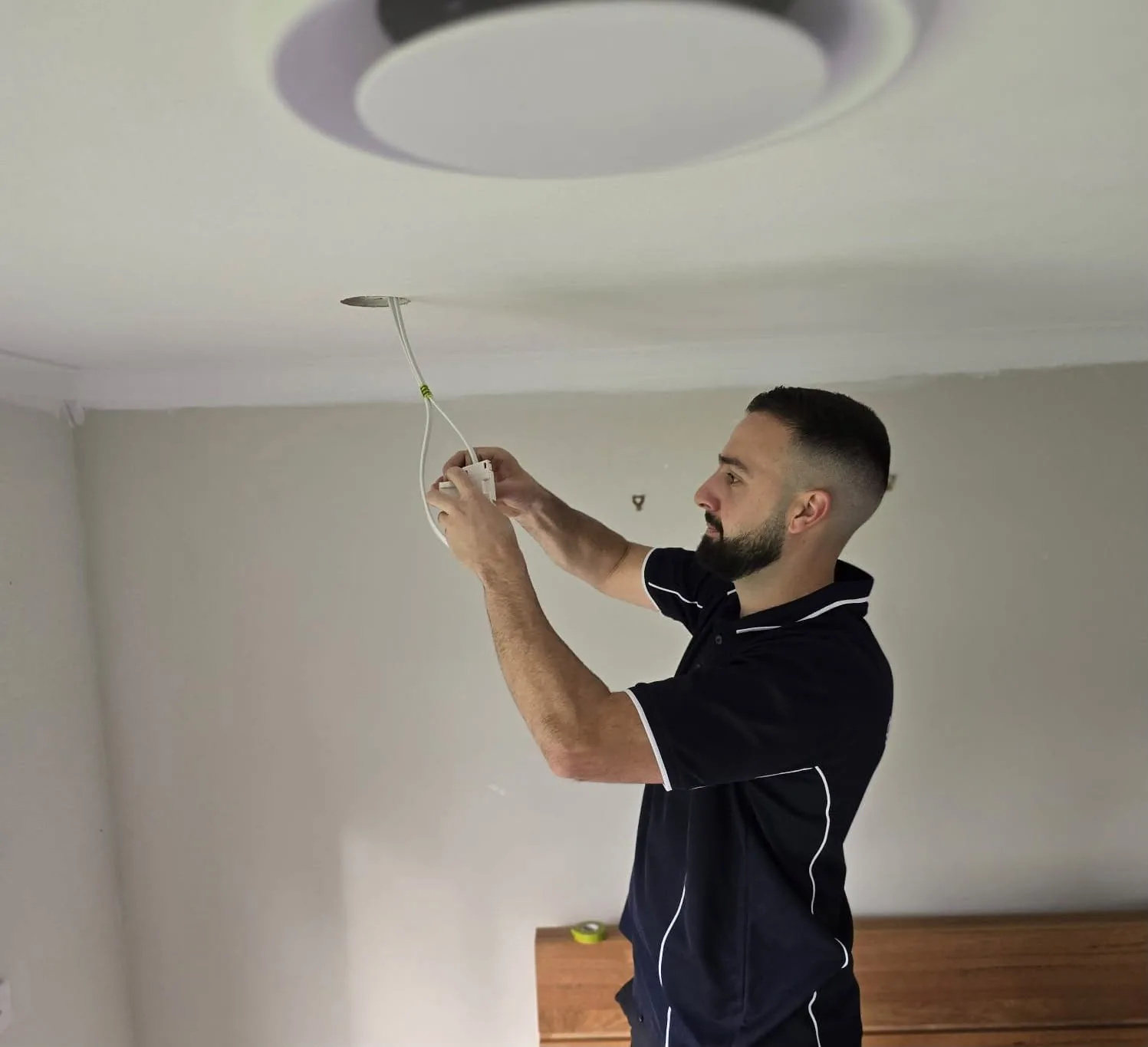 Kalin of C3 Industries wiring a fitting into the ceiling rose
