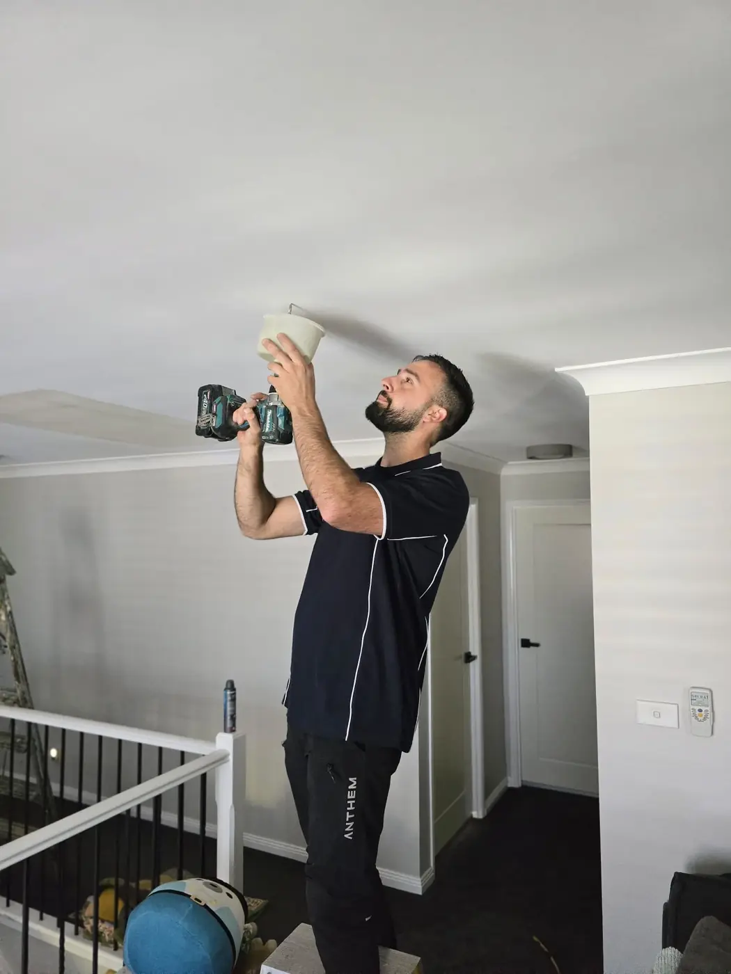 Kalin of C3 Industries fitting an LED downlight into a ceiling