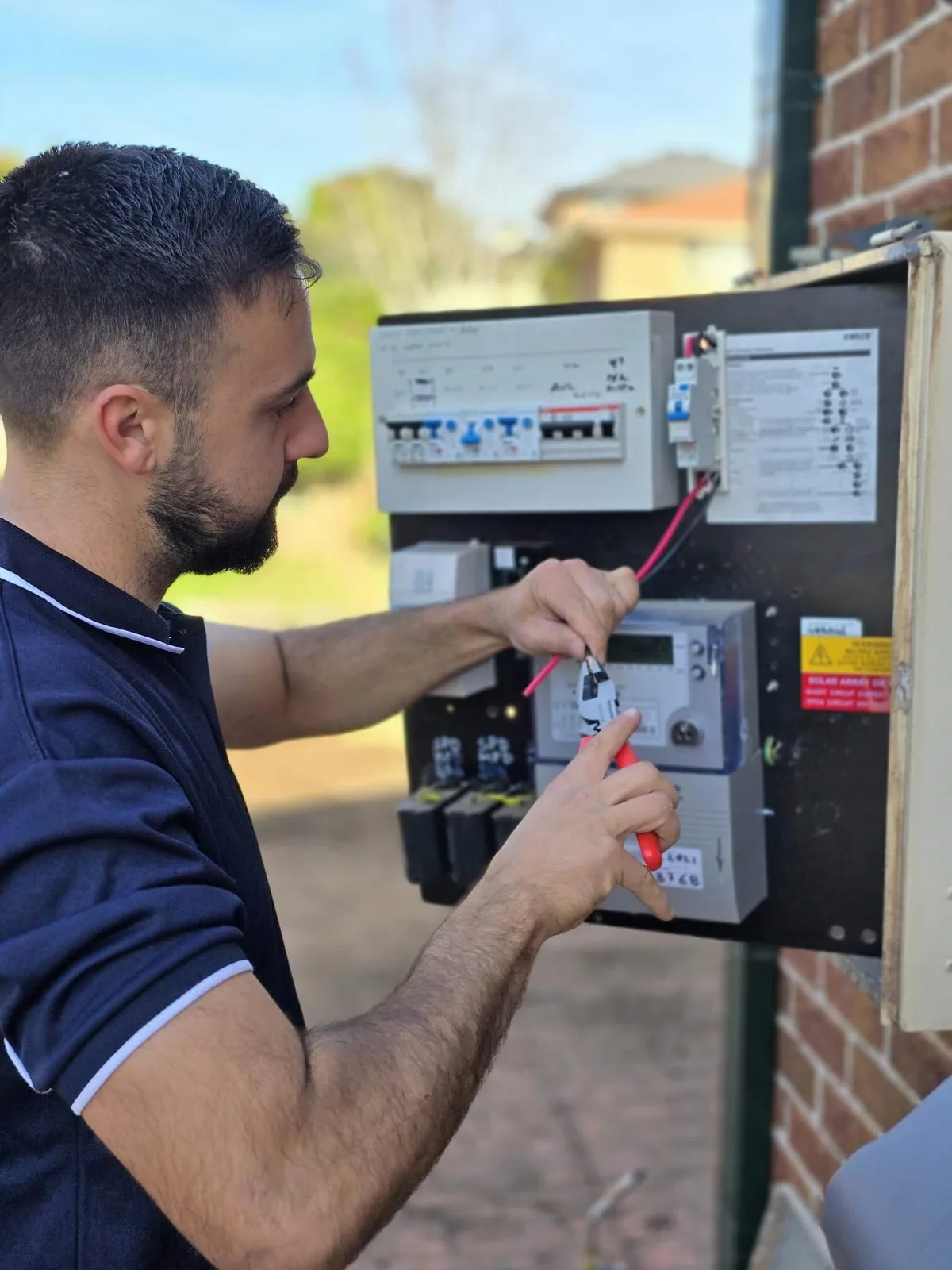 Kalin working on a switchboard at a Macarthur home